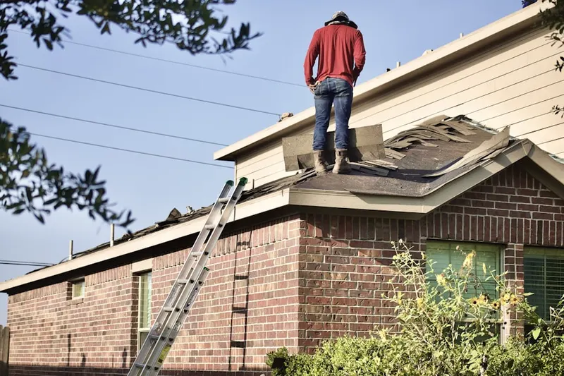 Professional roofer working on a residential roof in Roe Park